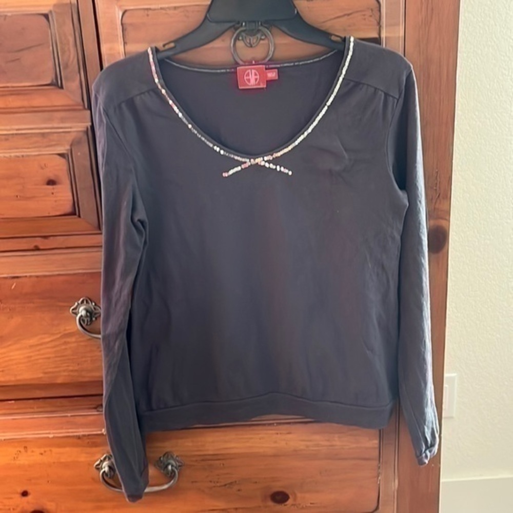 Women’s gray top with glitter neckline and binding around sleeves and bottom.